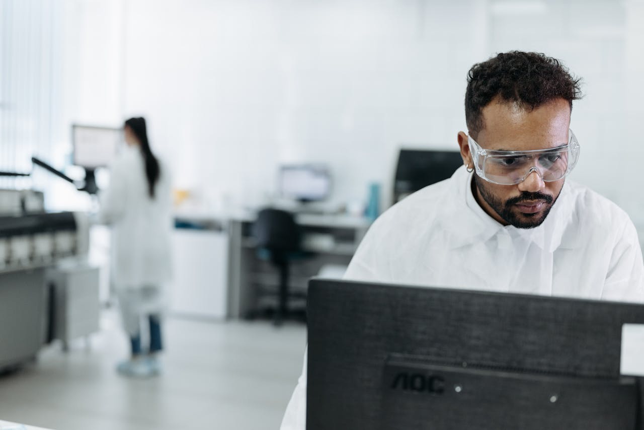 A scientist working diligently at a computer in a modern laboratory.